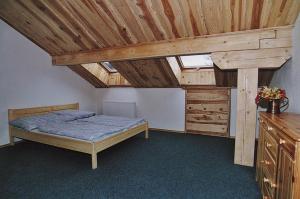 - une chambre avec un lit et un plafond en bois dans l'établissement Pension Klose, à Kubova Huť