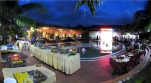 un restaurant avec des tables et une piscine la nuit dans l'établissement Sao Mai Phu My Resort, à Phú Mỹ 160 autres photos