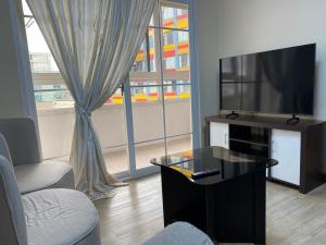 a living room with a flat screen tv and a table at Bang-kito City Central Suites in Baguio +23 photos