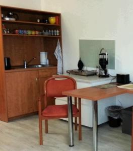 cocina con mesa de madera y silla roja en Sonniges Studio im Haus Deutsch Krone, en Bad Rothenfelde