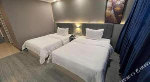 2 Betten in einem kleinen Zimmer mit blauen Vorhängen in der Unterkunft 7Days Inn Jining Zoucheng Sports Park in Zouxian