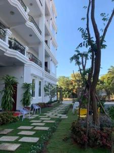 une cour avec des chaises et des arbres dans l'établissement Boutique Kampot Hotel, à Kampot