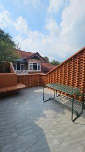un banc installé sur une terrasse à côté d'un mur de briques dans l'établissement Villa Panda, Your Private Holiday Home in Malang!, à Sengkaling 33 autres photos