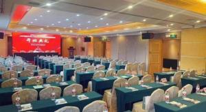 une salle de conférence avec des tables et des chaises bleues et un écran dans l'établissement Vienna International Shenzhen Tianan Digital City, à Longgang