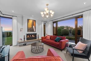 ein Wohnzimmer mit einem roten Sofa und einem Kamin in der Unterkunft Main House & Guest House - Group Perfect in Coatesville + 67 Fotos