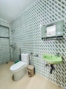 ein Badezimmer mit Toilette und Waschbecken in der Unterkunft Deeptis Guest House in Candolim