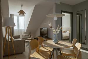 a living room with a table and chairs and a couch at Hotel Saltic Resort & Spa Grzybowo in Kołobrzeg
