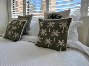 米兰达Miranda Stylish 2 Bed near Cronulla & Airport的一张带三个枕头的床和窗户