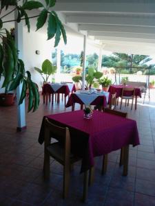 a restaurant with purple tables and chairs and plants at Agriturismo Tenuta Pozzello in Torre dell'Orso