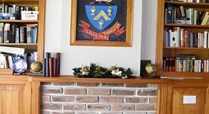 a fireplace with a sign on the wall and books at Fletcher Christian Holiday Hotel in Kingston +80 photos