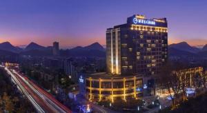 un bâtiment avec un panneau dessus la nuit dans l'établissement Yueyang Grand Skylight Hotel, à Yueyang