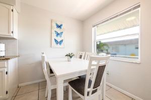 biała jadalnia z białym stołem i krzesłami w obiekcie Sun, Sand, Coastal Haven 3 w mieście Clearwater Beach