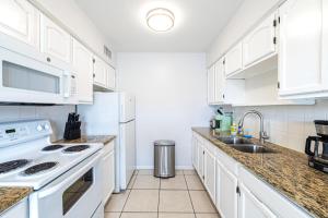 biała kuchnia z białymi szafkami i zlewem w obiekcie Sun, Sand, Coastal Haven 3 w mieście Clearwater Beach +18 zdjęć