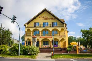 un edificio amarillo con un cartel. en Hotel Grodzki, en Sandomierz