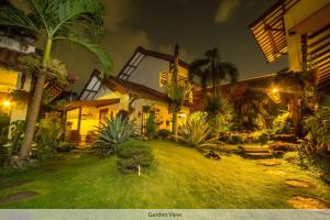 een huis met een tuin met palmbomen in de nacht bij Duta Guest House in Yogyakarta