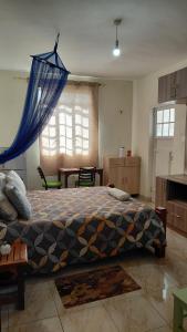 Un dormitorio con una cama grande con una manta azul. en IL Ladrone, en Ruiru