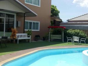 a swimming pool in front of a house at Le Parc Wangnang Hotel in Ban Ko