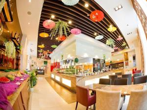 a restaurant with a bar with chairs and tables at Inzone Garlnd Hotel Zhangqiu in Zhangqiu