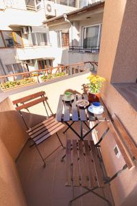 - un balcon avec une table et un banc dans un bâtiment dans l'établissement EpiCenter by RV Apartments, à Varna