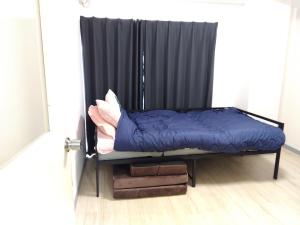 a bed in a room with a black curtain at SunandMoonホテル401 in Tokyo