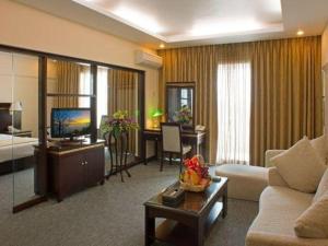 ein Wohnzimmer mit Sofa und Fernseher in einem Zimmer in der Unterkunft Huu Nghi Hotel in Haiphong