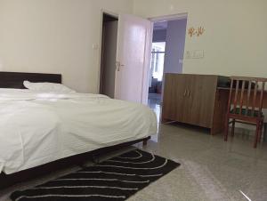 a bedroom with a bed and a room with a chair at Star Amaya Homestay River Side Mountain and Forest View in Kangra Airport