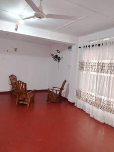 a living room with chairs and a curtain at Villa Aavanthana in Ambalangoda
