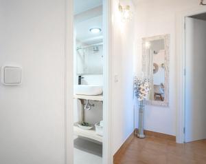 une salle de bain blanche avec un lavabo et un miroir dans l'établissement Bonito Piso a 1 minuto de la Playa, à La Antilla 27 autres photos