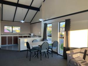 a kitchen and living room with a table and chairs at Mountain View Motel in Taupo