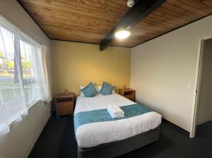 a bedroom with a bed and a large window at Mountain View Motel in Taupo +67 photos