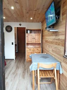 a kitchen with a table and a tv in a room at Le Bois Joli en Chartreuse in Saint-Pierre-de-Chartreuse