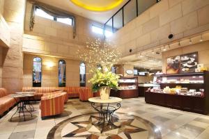 a lobby with a restaurant with a table and chairs at Hotel Piena Kobe in Kobe