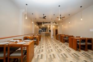 a dining room with wooden tables and chairs at Emerald Resort Hikkaduwa in Hikkaduwa