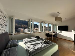 a bedroom with a bed and a desk and windows at Moderne Apartments in attraktivem Altbau in Freiburg im Breisgau