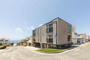 an apartment building on a street in front of the ocean at Tide House - Unit C - Modern Seaside 1BD w Parking in El Segundo