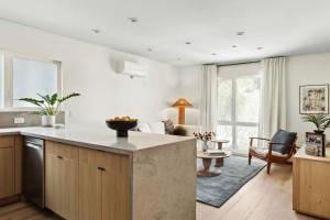 a kitchen and living room with a large island at Tide House - Unit C - Modern Seaside 1BD w Parking in El Segundo
