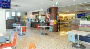 a restaurant with tables and chairs in a cafeteria at Ou Hotel in Yonago