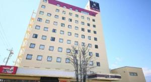 a tall building with a train in front of it at Hotel Naito Kofu Showa in Showa