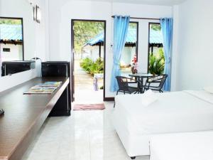 um quarto branco com uma cama, uma mesa e cadeiras em HaadSon Resort em Bang Saphan Noi