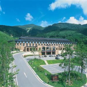 un grand bâtiment avec une route devant lui dans l'établissement Hotel de Premiere Minowa, à Numajiri
