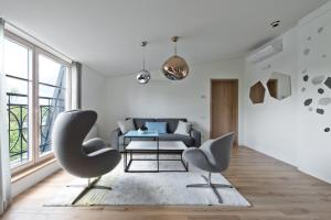 a living room with two chairs and a couch at Aura apartamentai in Druskininkai