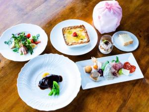 quatre assiettes de nourriture sur une table en bois dans l'établissement WISTERIAN LIFE CLUB Nojiriko, à Kashiwabara