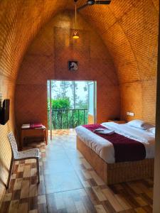 KanthalloorBhramaram resort的房间里有一张床和一把椅子的卧室