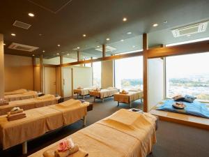 a hospital room with four beds and a large window at HOTEL CLAD in Gotemba