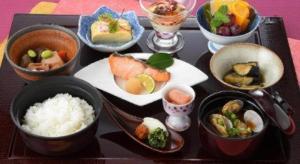 a tray with various bowls of food on a table at Hiroshima Diamond Hotel in Minami-kannommachi