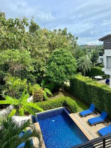 a view of a swimming pool with two blue chairs at Villa 3 Tropical Oasis with Private Pool in Plai Laem