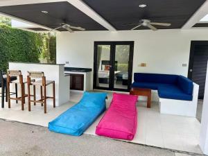 a living room with blue and pink pillows on the floor at Villa 3 Tropical Oasis with Private Pool in Plai Laem