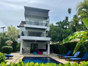 a villa with a swimming pool in front of a house at Villa 3 Tropical Oasis with Private Pool in Plai Laem