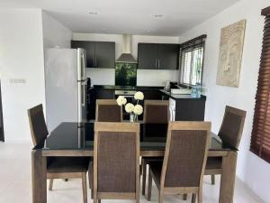 a kitchen with a table and chairs and a refrigerator at Villa 3 Tropical Oasis with Private Pool in Plai Laem