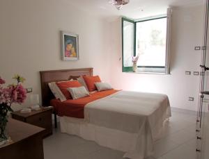 Un dormitorio con una cama con sábanas rojas y una ventana. en Flora, en Atrani